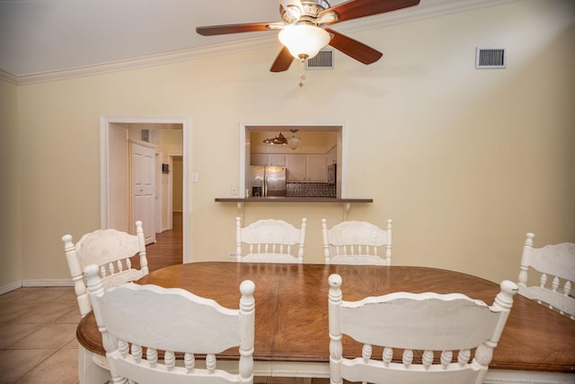 dining area with tile patterned floors, ornamental molding, and ceiling fan