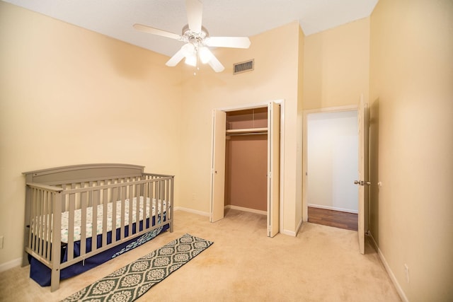 bedroom with light colored carpet, a closet, and ceiling fan