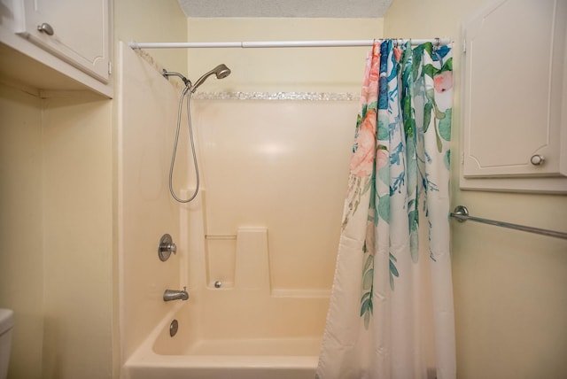 bathroom featuring shower / bathtub combination with curtain and a textured ceiling