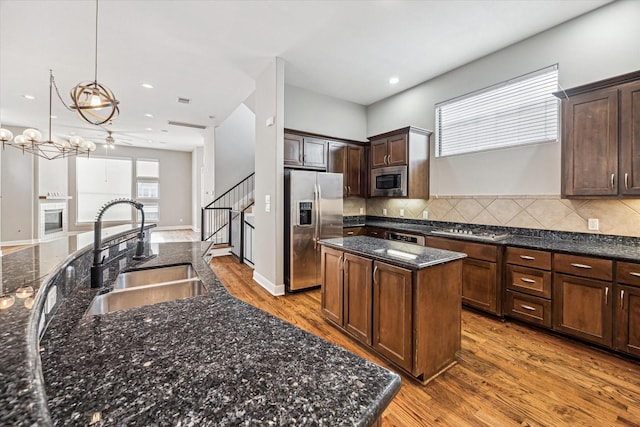 kitchen with sink, a center island, dark brown cabinets, pendant lighting, and stainless steel appliances