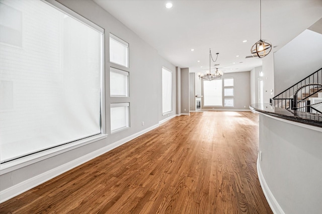 unfurnished living room featuring hardwood / wood-style flooring and a notable chandelier