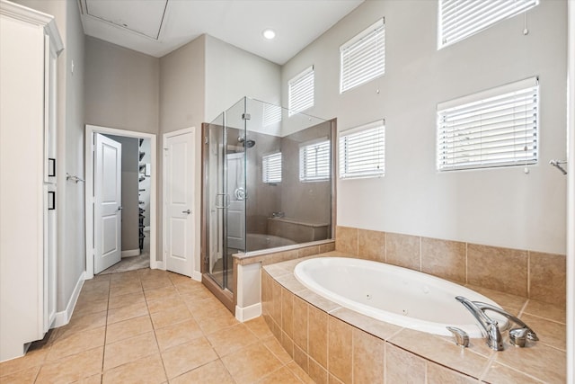 bathroom featuring a towering ceiling, tile patterned floors, and plus walk in shower