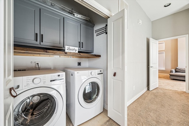 laundry area with cabinets, washing machine and dryer, and light colored carpet