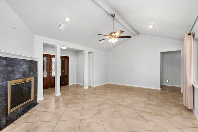 unfurnished living room featuring ornate columns, lofted ceiling with beams, light tile patterned floors, a tile fireplace, and ceiling fan