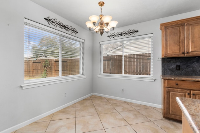 unfurnished dining area with an inviting chandelier and light tile patterned floors