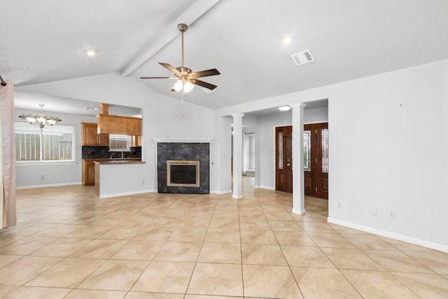 unfurnished living room with ceiling fan, a premium fireplace, decorative columns, and light tile patterned floors