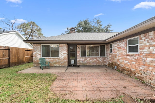 back of house with a yard and a patio