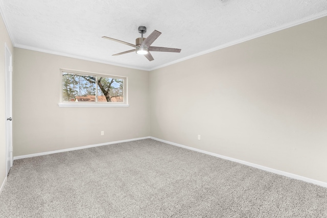 carpeted spare room featuring ornamental molding, a textured ceiling, baseboards, and a ceiling fan