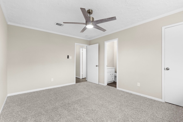 unfurnished bedroom with a textured ceiling, visible vents, baseboards, ornamental molding, and dark colored carpet