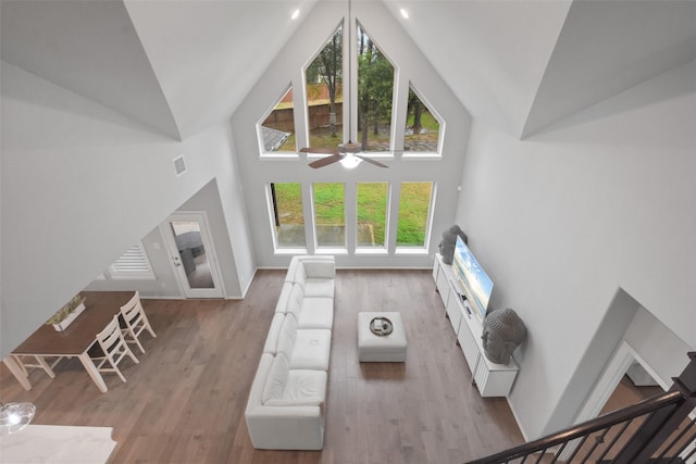 unfurnished living room featuring high vaulted ceiling, ceiling fan, and light wood-type flooring