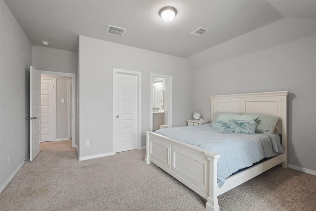 carpeted bedroom with vaulted ceiling and ensuite bathroom