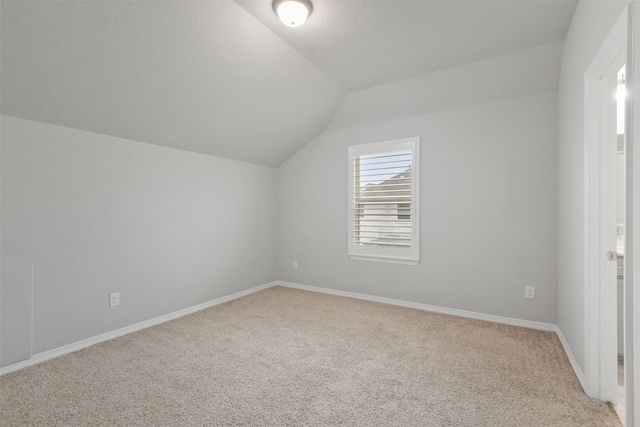 bonus room with light colored carpet and lofted ceiling