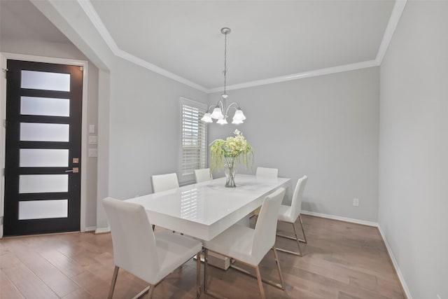 dining space featuring crown molding, a chandelier, and hardwood / wood-style floors