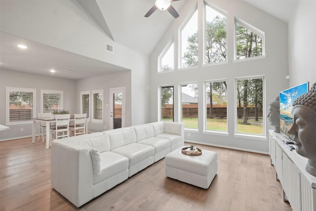 living room with high vaulted ceiling, light hardwood / wood-style floors, and ceiling fan