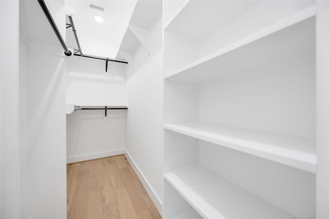 walk in closet with wood-type flooring