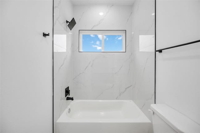 bathroom featuring toilet and tiled shower / bath