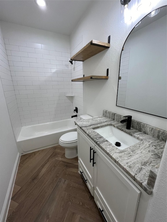 full bathroom featuring vanity, tiled shower / bath combo, and toilet