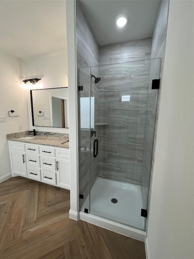 bathroom with vanity, parquet flooring, and walk in shower