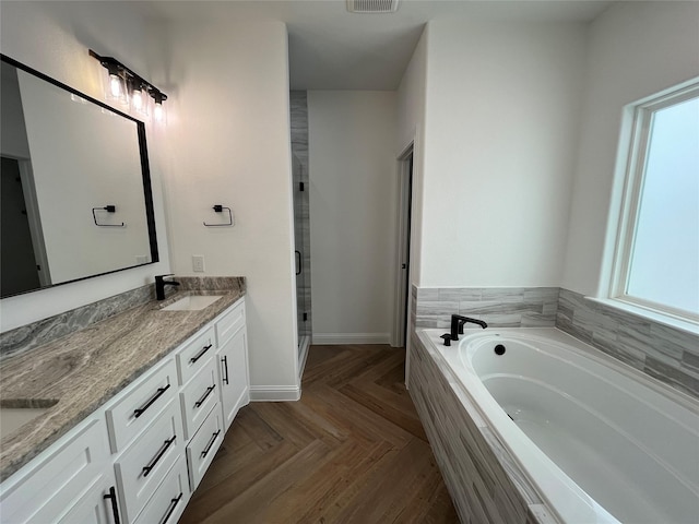 bathroom featuring parquet floors, vanity, and shower with separate bathtub