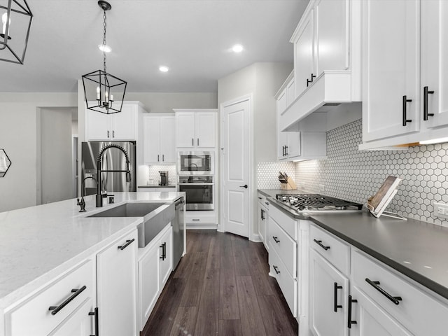 kitchen featuring white cabinetry, appliances with stainless steel finishes, sink, and pendant lighting