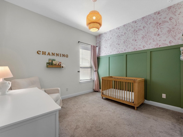 bedroom with light colored carpet and a nursery area