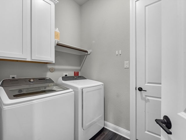 laundry room with cabinets, washing machine and dryer, and dark hardwood / wood-style floors