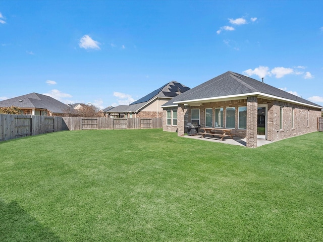 back of property with a yard and a patio area