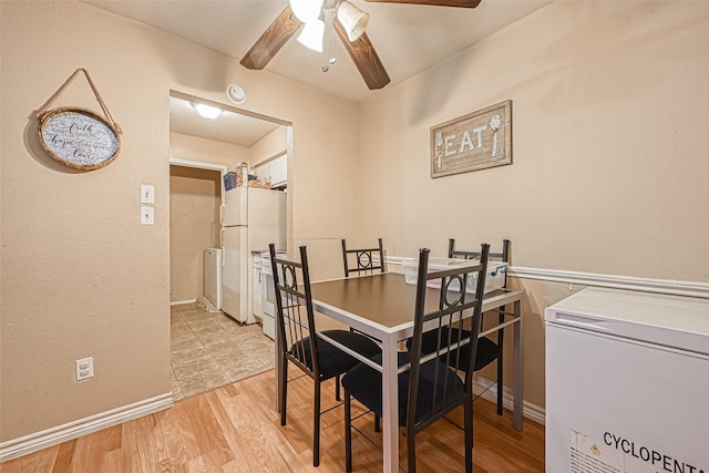 dining area with ceiling fan, light wood-type flooring, and washer and clothes dryer