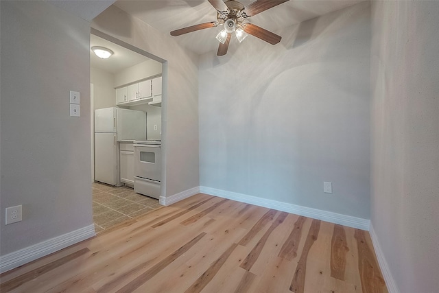 spare room with ceiling fan and light wood-type flooring