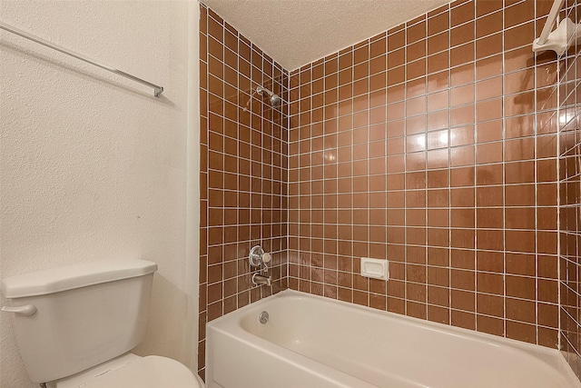 bathroom with tiled shower / bath combo, a textured ceiling, and toilet