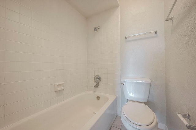 bathroom with tiled shower / bath, toilet, and tile patterned flooring