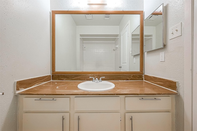 bathroom with vanity and a shower