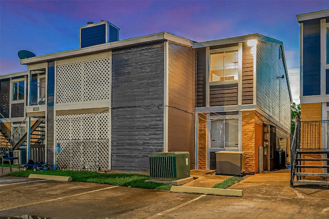 back house at dusk with central air condition unit