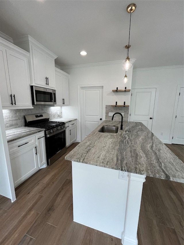 kitchen featuring a kitchen island with sink, sink, stainless steel appliances, and white cabinets