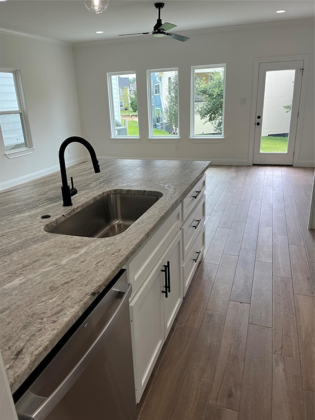 kitchen featuring sink, light stone counters, stainless steel dishwasher, ornamental molding, and white cabinets