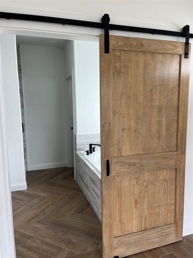 bathroom featuring parquet floors and tiled tub