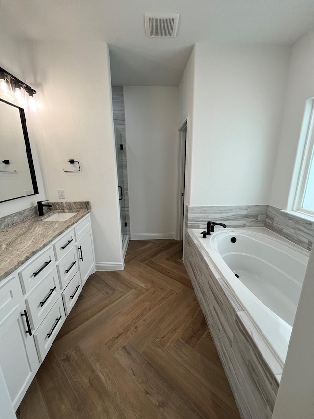 bathroom with parquet flooring, vanity, and shower with separate bathtub