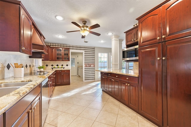 kitchen with ornate columns, light tile patterned flooring, appliances with stainless steel finishes, ceiling fan, and a textured ceiling