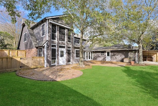 rear view of house featuring a lawn and a patio