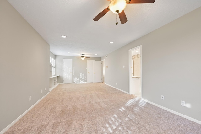 unfurnished living room featuring light colored carpet and ceiling fan