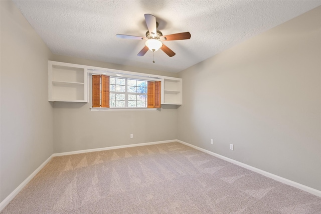 carpeted spare room featuring ceiling fan and a textured ceiling