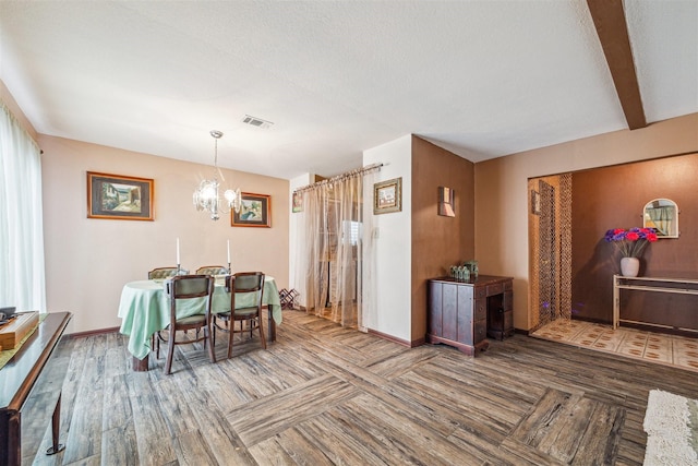 dining space featuring an inviting chandelier, beamed ceiling, a textured ceiling, and hardwood / wood-style flooring