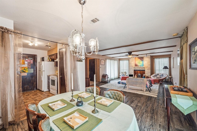 dining area with a brick fireplace, hardwood / wood-style flooring, and ceiling fan with notable chandelier