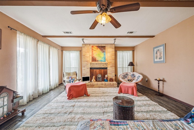 living room featuring ceiling fan, a fireplace, and dark hardwood / wood-style flooring