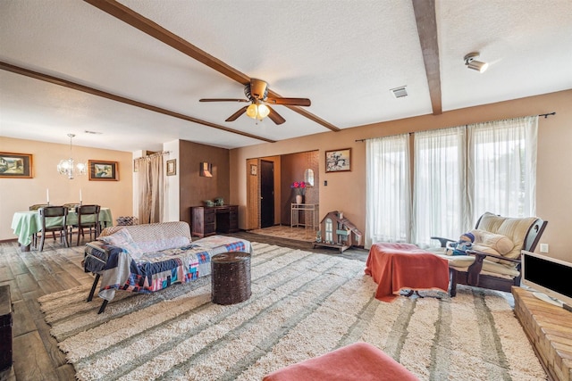 living room with beam ceiling, wood-type flooring, a textured ceiling, and ceiling fan with notable chandelier