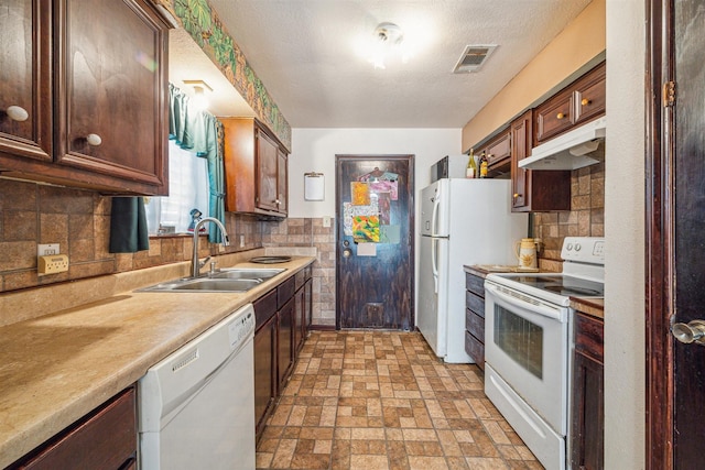 kitchen featuring white appliances, sink, decorative backsplash, and a textured ceiling