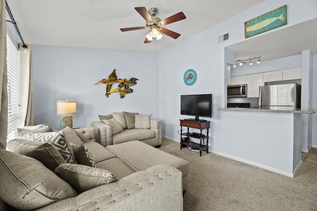 carpeted living room featuring vaulted ceiling, rail lighting, and ceiling fan