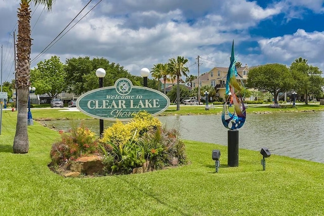 view of property's community featuring a lawn and a water view