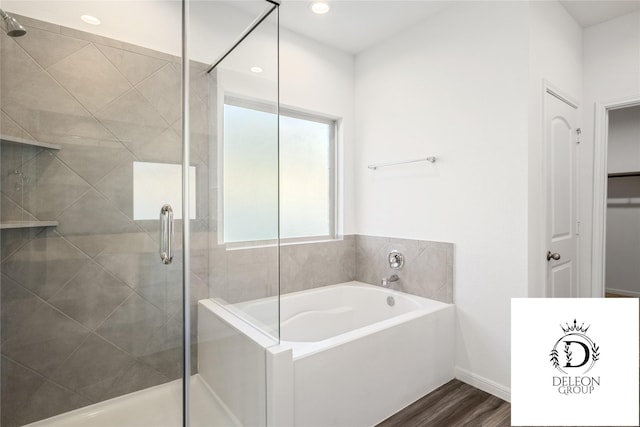 bathroom with hardwood / wood-style flooring and separate shower and tub