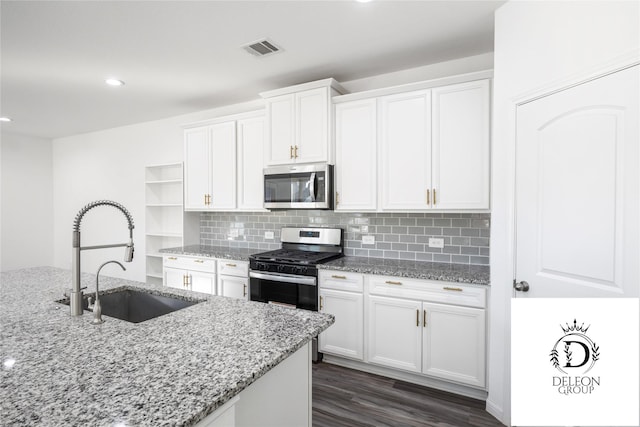 kitchen featuring stainless steel appliances, light stone countertops, sink, and white cabinets